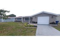 Charming single-story home with a well-manicured front yard and an attached garage at 7024 Coral Reef Dr, Port Richey, FL 34668