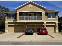 Traditional home featuring a balcony, attached garages, and well-manicured landscaping at 8405 Blue Rock Dr, New Port Richey, FL 34653