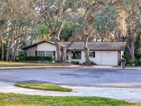 Charming single-story home featuring stone accents, mature trees, and a well-maintained lawn at 10635 Timber Ln, Port Richey, FL 34668