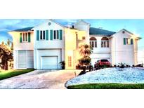 Stunning two-story home with lush landscaping, two-car garage and turquoise window shutters at 121 Augusta Ave, Palm Harbor, FL 34683