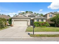 Charming single-story home featuring a manicured lawn, a two-car garage, and inviting curb appeal at 1250 Halapa Way, Trinity, FL 34655