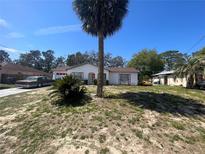 Quaint single-story home featuring a well-manicured front yard with mature trees and a long driveway at 2335 Canfield Dr, Spring Hill, FL 34609