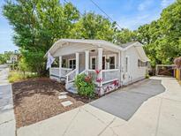 Charming home featuring a covered front porch, landscaping, and a concrete driveway at 4816 N Highland Ave, Tampa, FL 33603