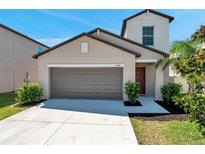 Charming home featuring a two-car garage and landscaped front yard at 6068 Apple Snail Ave, New Port Richey, FL 34653