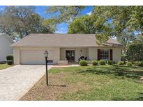 Charming single-story home with brick driveway, well-maintained lawn, and inviting front porch at 6530 Pine Meadows Dr, Spring Hill, FL 34606