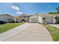 Inviting front exterior showcases a long driveway and attached garage at 11735 Rolling Pine Ln, Port Richey, FL 34668