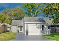 Charming single-story home with an attached garage and well-maintained lawn at 152 Chelsea Ct, Dunedin, FL 34698