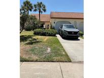 Charming home with a well-maintained front yard and a paved driveway leading to the garage at 3054 Pelican Pl, Clearwater, FL 33762