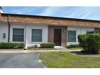 Inviting condo exterior with brown roof, front door and well-manicured landscaping at 6037 Chesham Dr # 3, New Port Richey, FL 34653