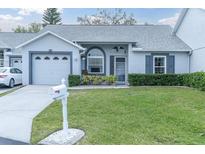 Charming single-story home featuring well-manicured lawn and attached one-car garage at 9348 Villa Entrada, New Port Richey, FL 34655