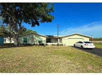 Charming single-story home with well-maintained lawn, a garage, and a car in the driveway at 12037 Boynton Ln, New Port Richey, FL 34654