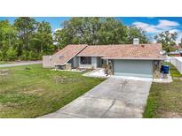Charming single-story home featuring a well-manicured lawn and an attached two-car garage at 12087 Tallwood St, Spring Hill, FL 34608