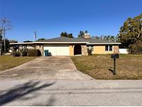Charming single-story home with stone accents, a covered carport, and an inviting driveway at 2349 Holston Ave, Spring Hill, FL 34608