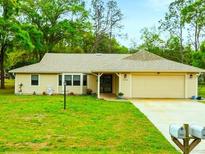 Charming single-story home featuring a well-maintained lawn, attached two-car garage, and traditional architecture at 24104 Peppermill Dr, Brooksville, FL 34601