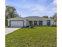 Charming single-story home with a well-manicured lawn, attached two-car garage, and inviting curb appeal at 3416 Lema Dr, Spring Hill, FL 34609