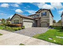 Beautiful two-story home featuring a tile roof, a three-car garage, and lush landscaping at 4012 Dragonfly Trl, Odessa, FL 33556