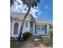 Charming condo features a well-maintained exterior with a mature palm tree, blue shutters and decorative window details at 4235 Sheldon Pl # 4235, New Port Richey, FL 34652