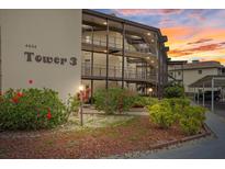 Beautiful condo building with lush landscaping and covered walkways at 4632 Marine Pkwy # 201, New Port Richey, FL 34652