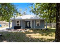 Charming single-story home with a white metal roof, blue-gray siding, and a well-maintained front yard at 5342 Leisure St, Dade City, FL 33523