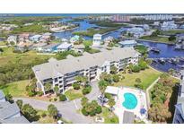 An aerial view of a waterfront condominium with a pool and canal access in a beautiful coastal setting at 5537 Sea Forest Dr # 301, New Port Richey, FL 34652