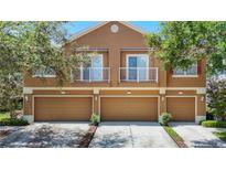 Charming townhouse with a multi-car garage, tan exterior, and delightful balcony spaces at 6821 Breezy Palm Dr, Riverview, FL 33578