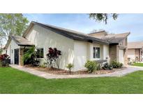 Charming one-story home featuring lush landscaping, mulch beds, and neutral stucco exterior at 7495 Heather Walk Dr, Weeki Wachee, FL 34613