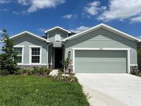 Charming single-Gathering home featuring a two-car garage, manicured lawn, and inviting curb appeal at 10012 Zennia Ln, Parrish, FL 34219
