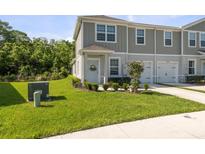 Charming townhome with well-manicured lawn and landscaping, featuring a one-car garage and neutral color scheme at 12214 Grizzly Ln, New Port Richey, FL 34654