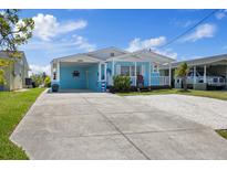 Charming blue home with a large driveway, carport, and a decorative nautical theme at 4400 Floramar Ter, New Port Richey, FL 34652