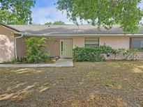 Charming one-story home with stucco exterior and lush landscaping, showcasing a welcoming entrance at 4503 Sheffield Rd, Land O Lakes, FL 34639