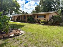 Manicured front lawn with charming landscaping, showcasing the exterior of this inviting single-story home at 5406 Dartmouth Rd, New Port Richey, FL 34652