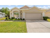 Charming single-story home with a manicured lawn, two-car garage, and well-maintained landscaping at 5676 Legend Hills Ln, Spring Hill, FL 34609
