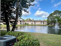 Scenic view of complex buildings overlooking a serene pond with a fountain feature at 6527 Spring Flower Dr # 24, New Port Richey, FL 34653
