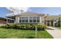 Charming mobile home with well-manicured lawn and carport at 846 Oakwood Dr, Tarpon Springs, FL 34689