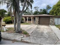 Charming single-story home featuring a stone-accented garage and arched entryway at 11515 Meredith Ln, Port Richey, FL 34668