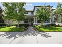 Charming two-story home with landscaped yard and a cozy front porch with rocking chairs at 12272 Rangeland Blvd, Odessa, FL 33556