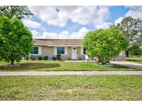 Charming single-story home featuring manicured lawn and well-maintained landscaping at 12478 Prescott St, Spring Hill, FL 34609