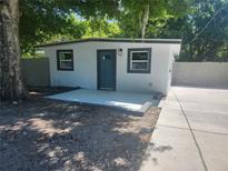 Charming home featuring a front door, windows, and a newly-laid patio, perfect for welcoming guests at 825 Lincoln Ave, Tarpon Springs, FL 34689