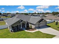 Wide aerial view of a single-Gathering home with a long driveway and a fenced backyard at 12848 Hilary St, Spring Hill, FL 34609