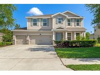 Inviting two-story home featuring a three-car garage, manicured lawn and charming curb appeal at 13619 Hunters Point St, Spring Hill, FL 34609