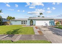 Charming single-story home with a well-manicured lawn and a two-car garage in a quiet residential neighborhood at 155 Patty Ann Blvd, Palm Harbor, FL 34683