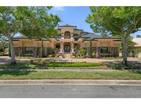 Elegant front exterior features manicured landscaping, stone accents, and a grand entrance at 3026 Wentworth Way, Tarpon Springs, FL 34688