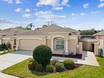 Charming single-story home featuring a manicured lawn, attached garage, and neutral color palette at 305 Royal Palm Way, Spring Hill, FL 34608