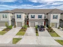 Attractive townhome with two stories, a neutral color palette, and manicured landscaping at 31718 Blue Passing Loop, Wesley Chapel, FL 33545