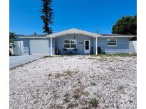 Charming single story home featuring a garage, blue paint and rock landscaping at 3309 Bayport Dr, Holiday, FL 34691