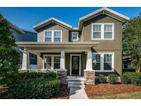 Charming two-story home featuring a covered porch with stone accents and manicured landscaping at 3515 Albritton St, New Port Richey, FL 34655