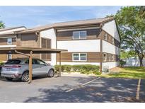 Two-story condo with covered parking, showcasing its architecture and manicured landscaping at 4140 Passport Ln # 204, New Port Richey, FL 34653