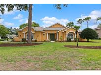 Charming home featuring a well-maintained lawn, lush landscaping, and inviting curb appeal at 5110 Championship Cup Ln, Spring Hill, FL 34609