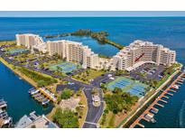 Stunning aerial view of waterfront condos, manicured grounds, tennis courts, and boat docks at 6035 Sea Ranch Dr # 209, Hudson, FL 34667