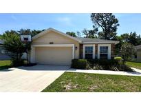 Charming single-story home featuring a two-car garage and nicely landscaped front yard at 6054 Merrifield Dr, Zephyrhills, FL 33541